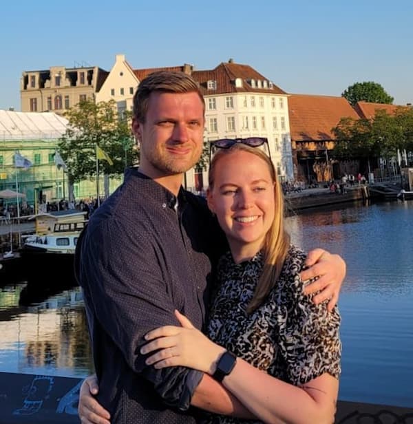 Till und Melina stehen an der Trave und lachen in die Kamera